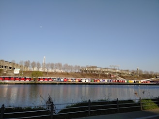 A fleet of modern buses lined up ready for export at a busy port.
