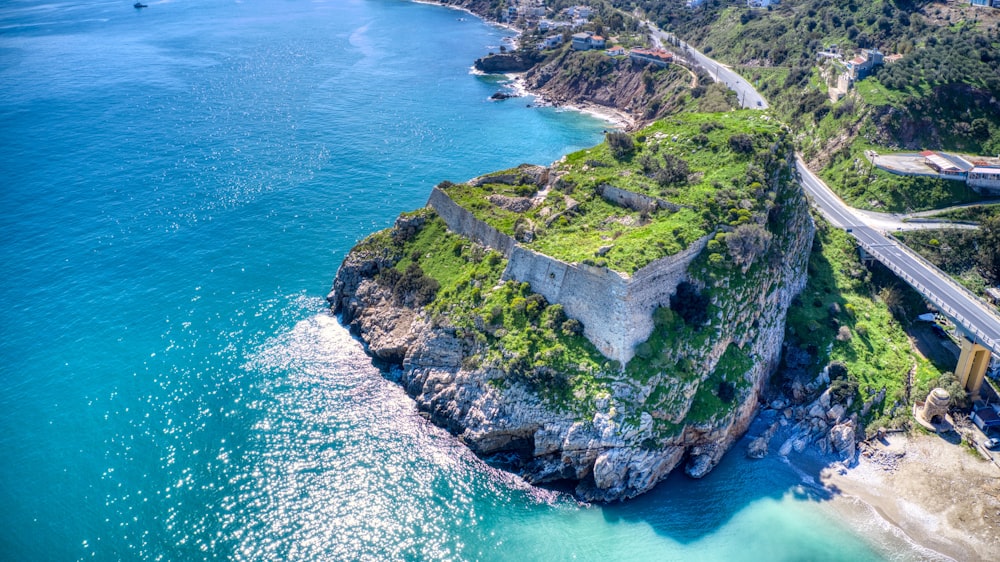 green and brown rock formation beside blue sea during daytime