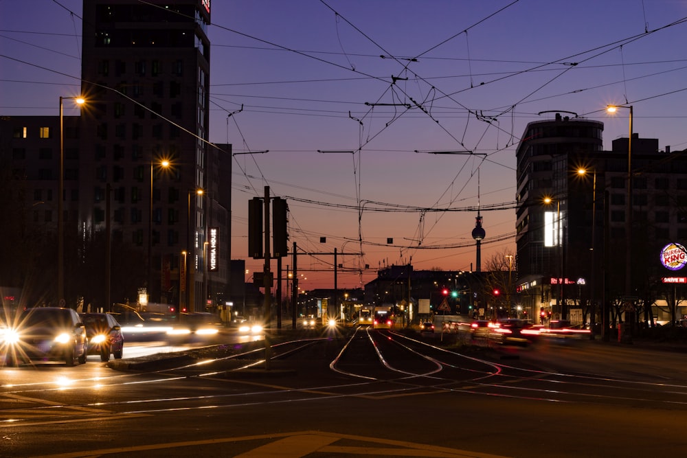 cars on road between buildings during night time