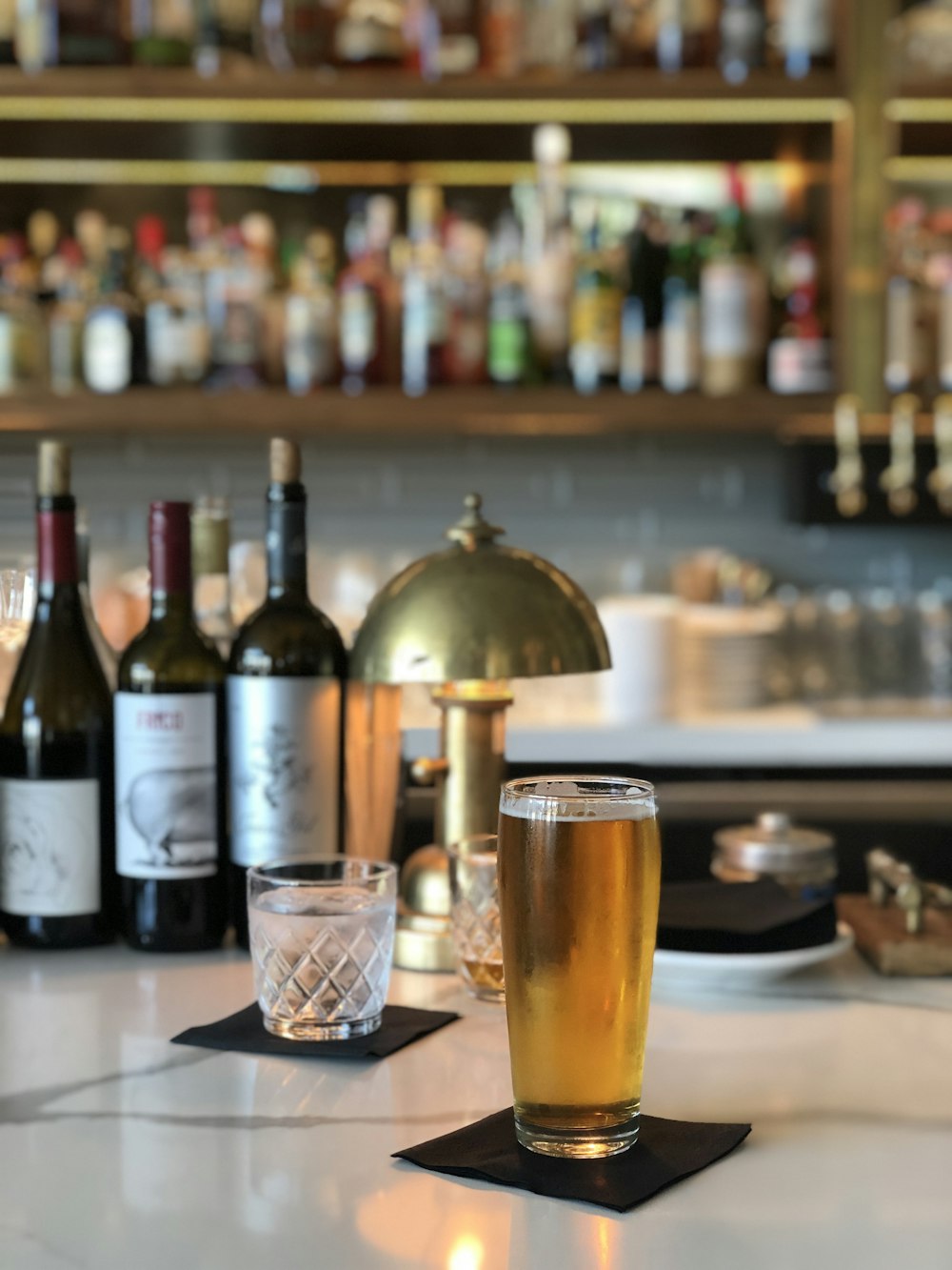 clear drinking glass beside wine bottle on table