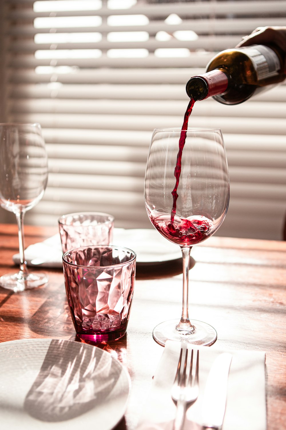 verre à vin transparent avec du vin rouge