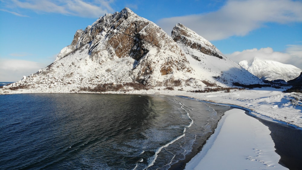 white and brown mountain near body of water during daytime