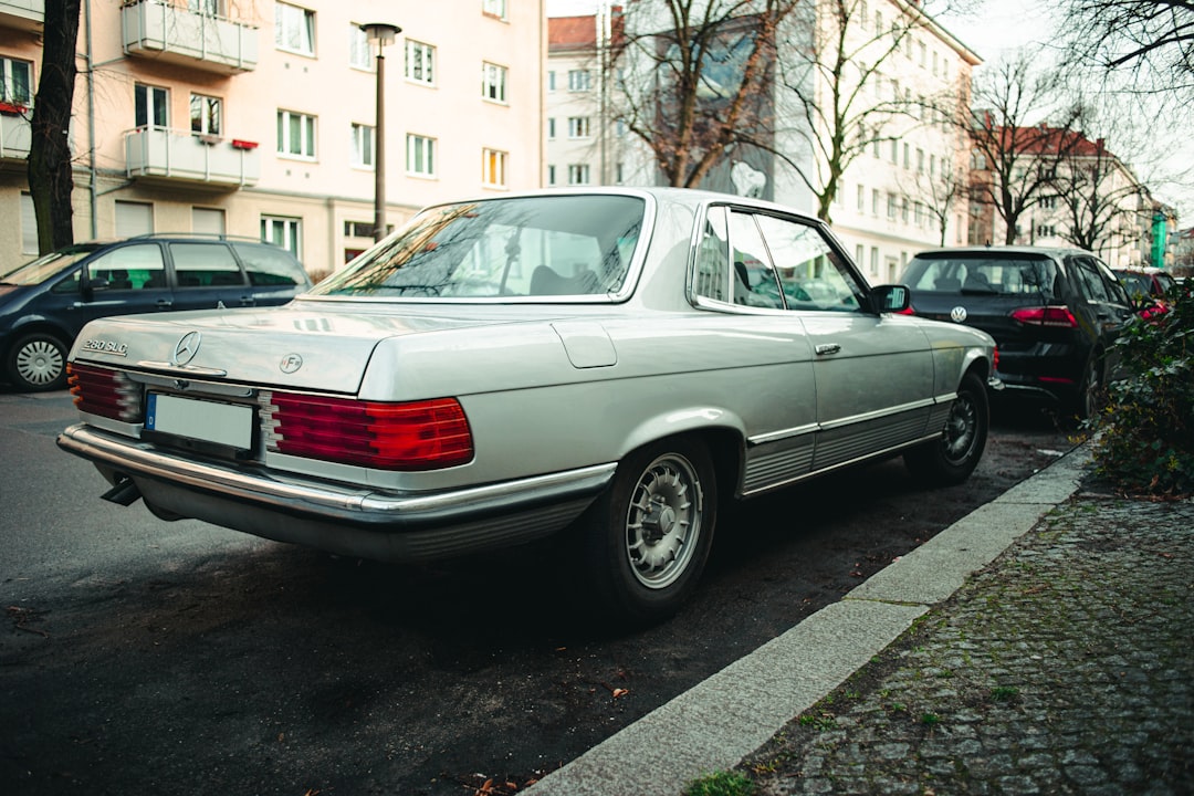 white sedan parked on sidewalk during daytime