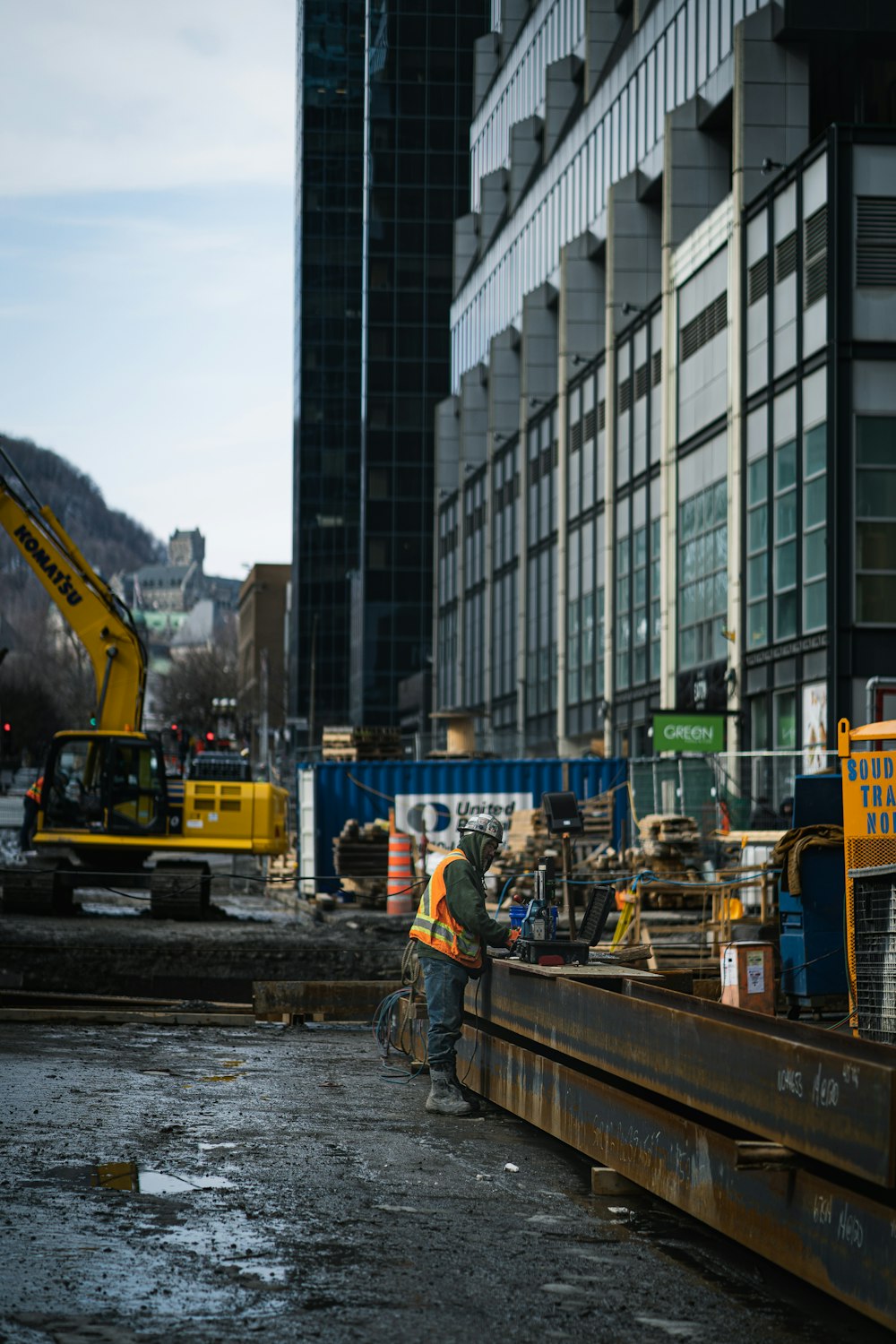 yellow crane on body of water near city buildings during daytime