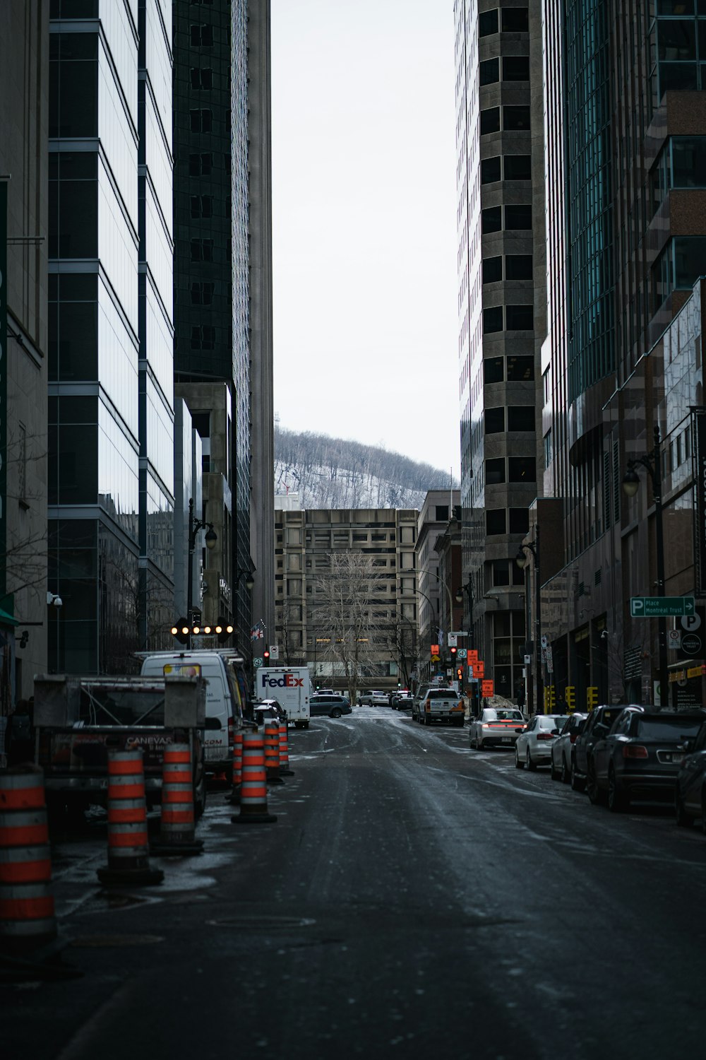 cars on road between high rise buildings during daytime