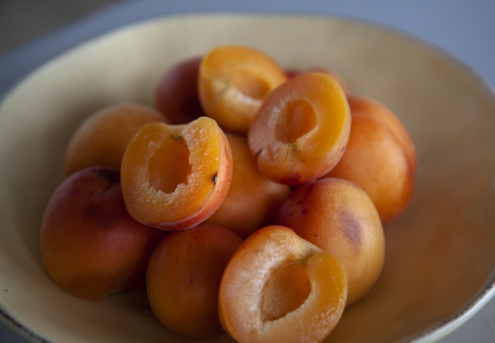 frutti arancioni su piatto di ceramica bianca