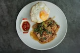 A vibrant plate of nasi goreng topped with fresh vegetables and a fried egg.