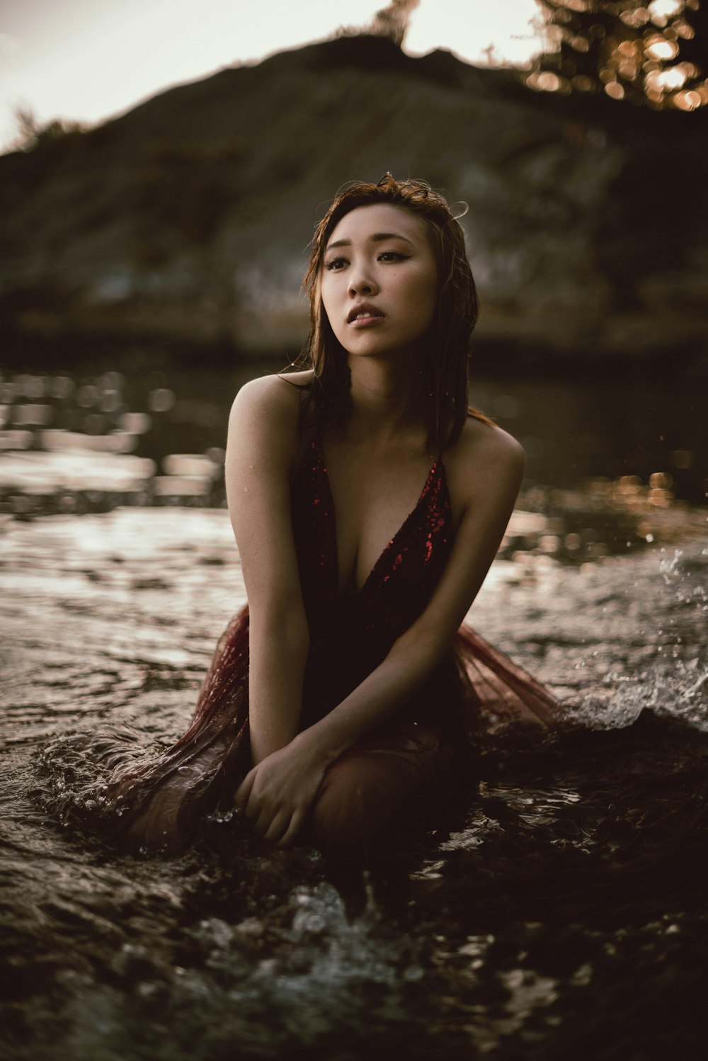 woman in red sleeveless dress sitting on water