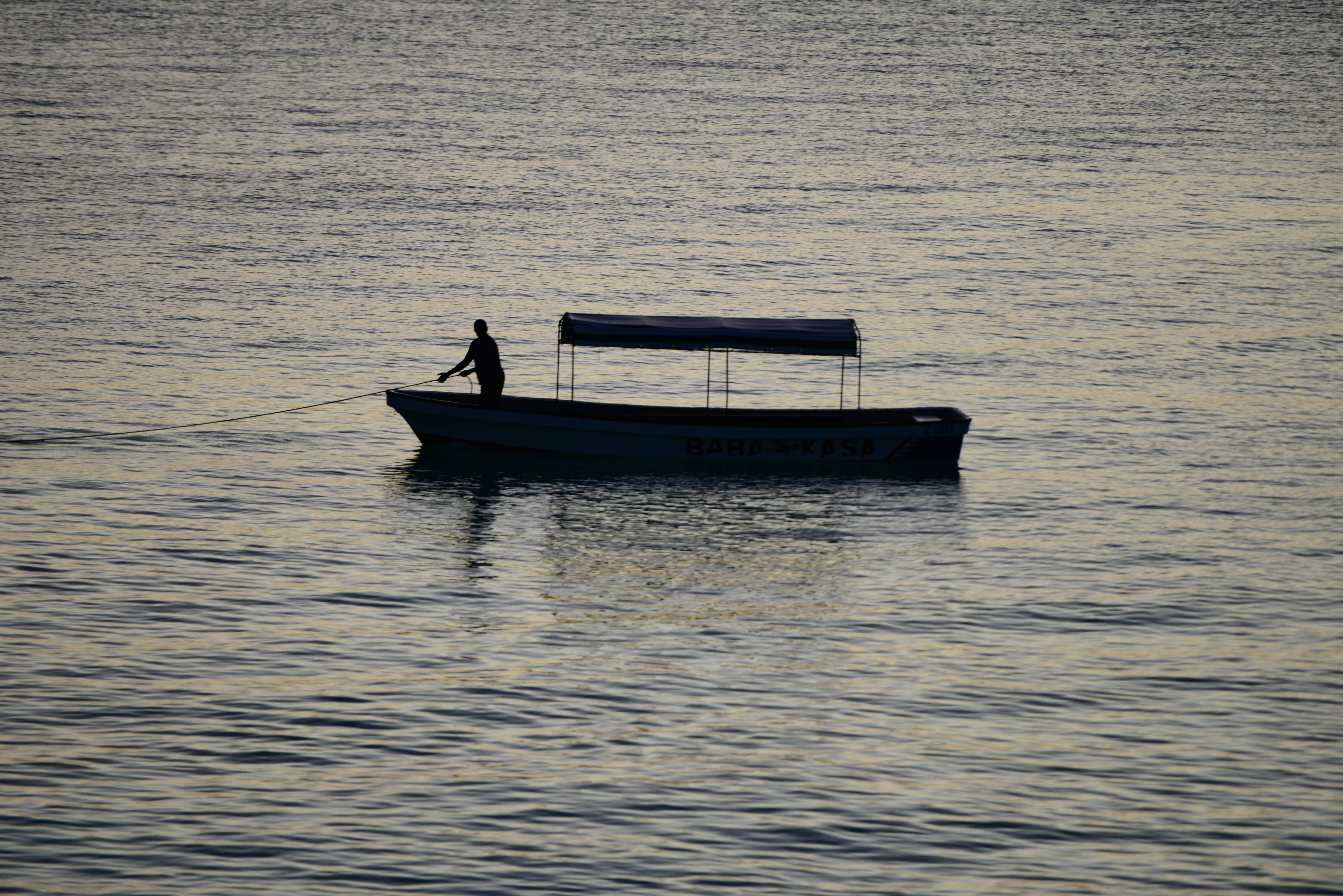 Mann in blauem Boot tagsüber auf See