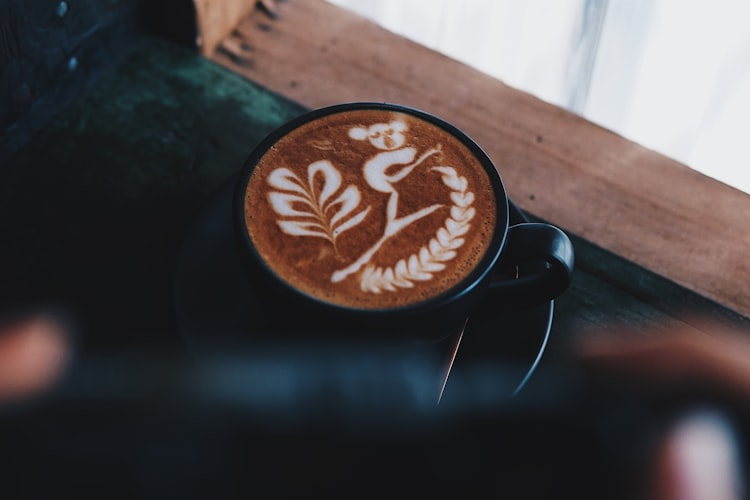 Coffee with milk in a dark mug