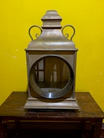 A classic marine ship lantern with intricate metalwork, resting on a polished surface.
