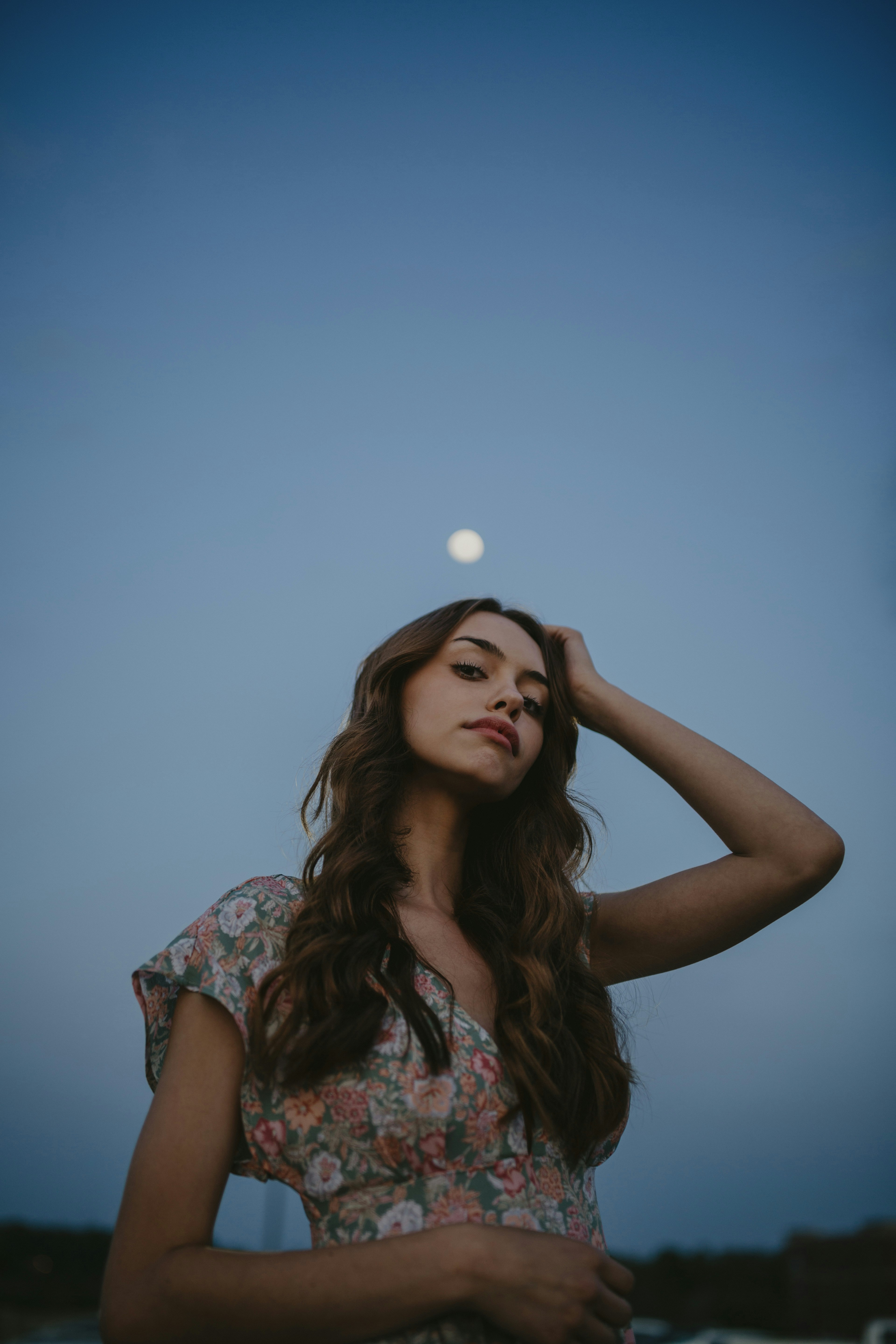woman in blue and white floral dress holding white round ornament