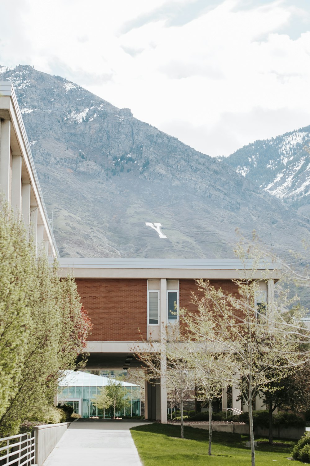 brown and gray house near green trees and mountain during daytime