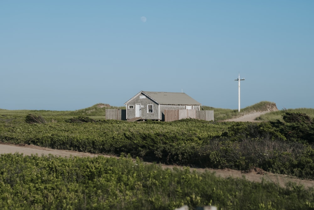 white and brown house on green grass field under blue sky during daytime