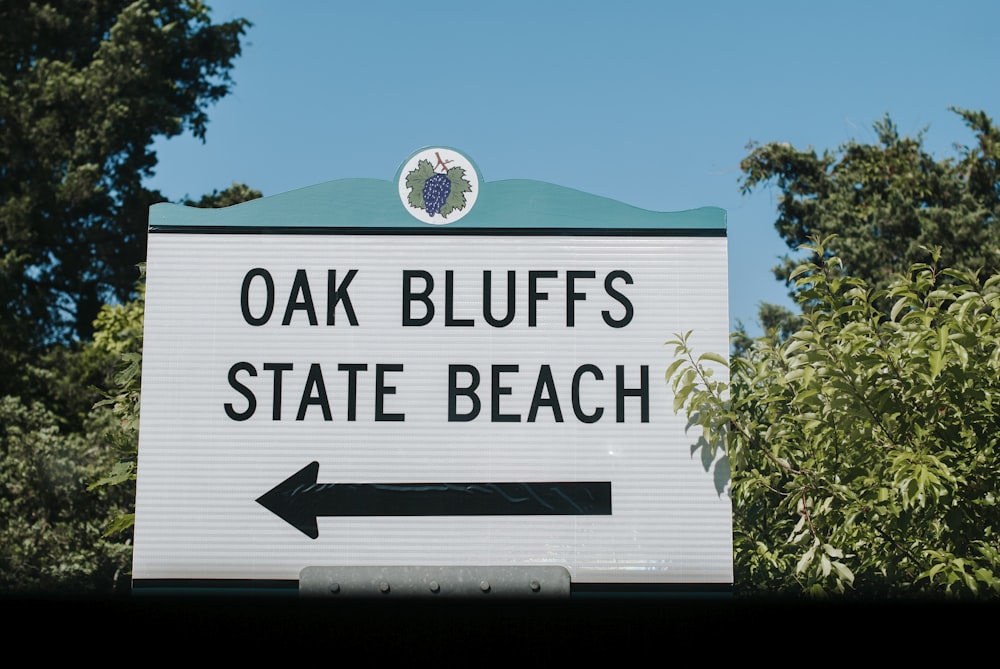 오크 블러프 주립 해변을 가리키는 검은색 화살표가 있는 흰색 표지판