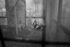 A sepia-toned photograph of Harry Berg in his workshop, surrounded by vintage industrial tools.