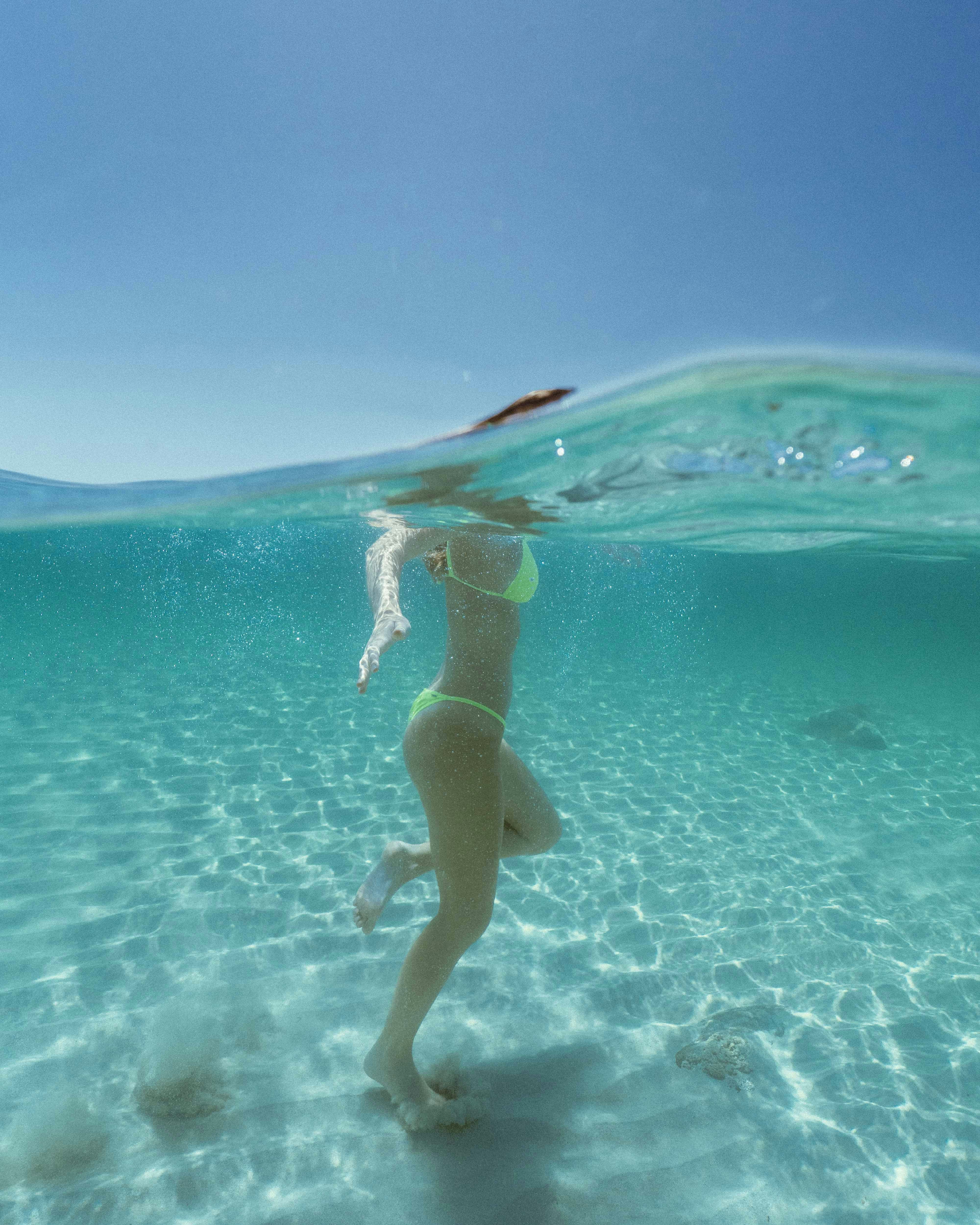 woman in blue bikini swimming on water during daytime