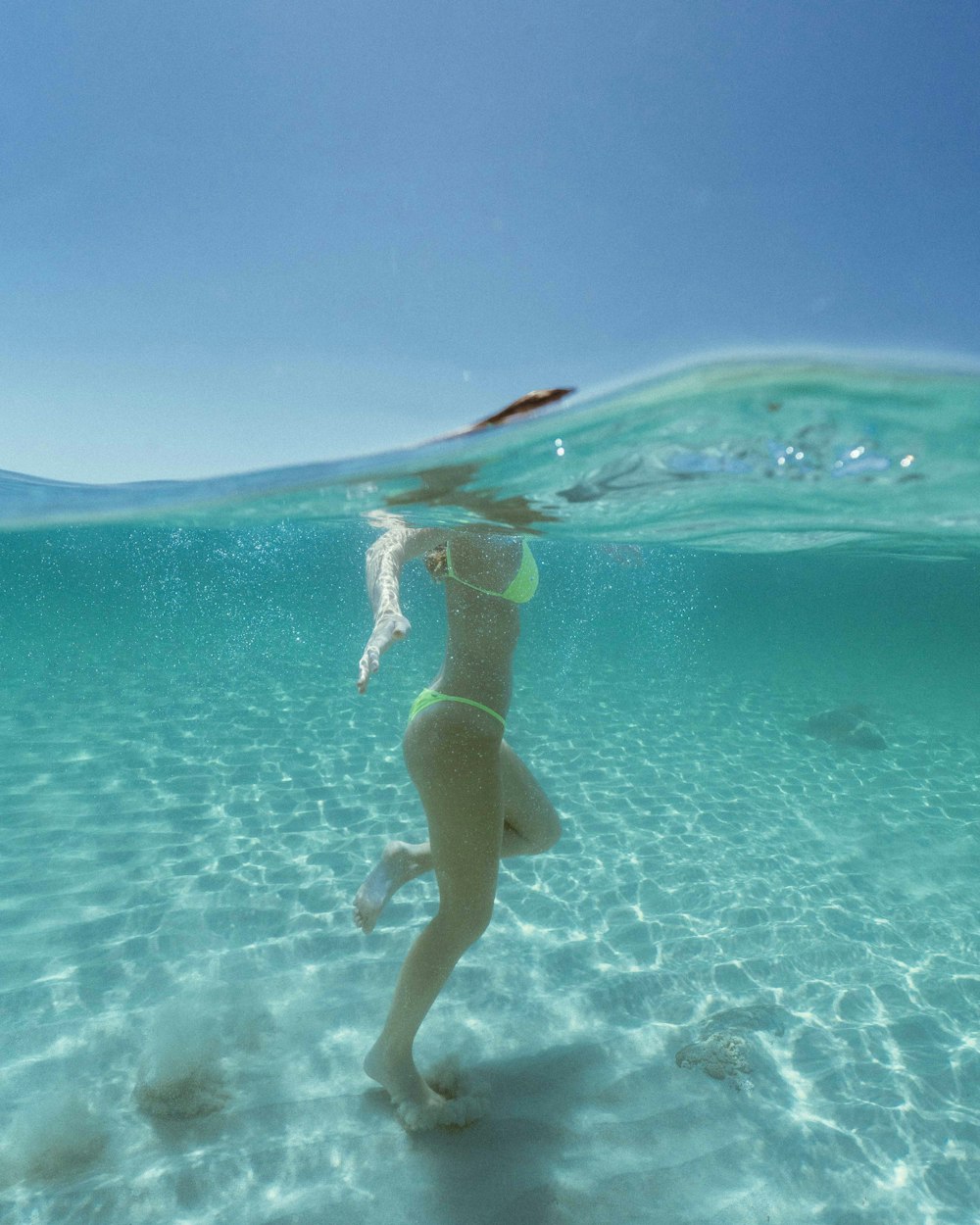 donna in bikini blu che nuota sull'acqua durante il giorno