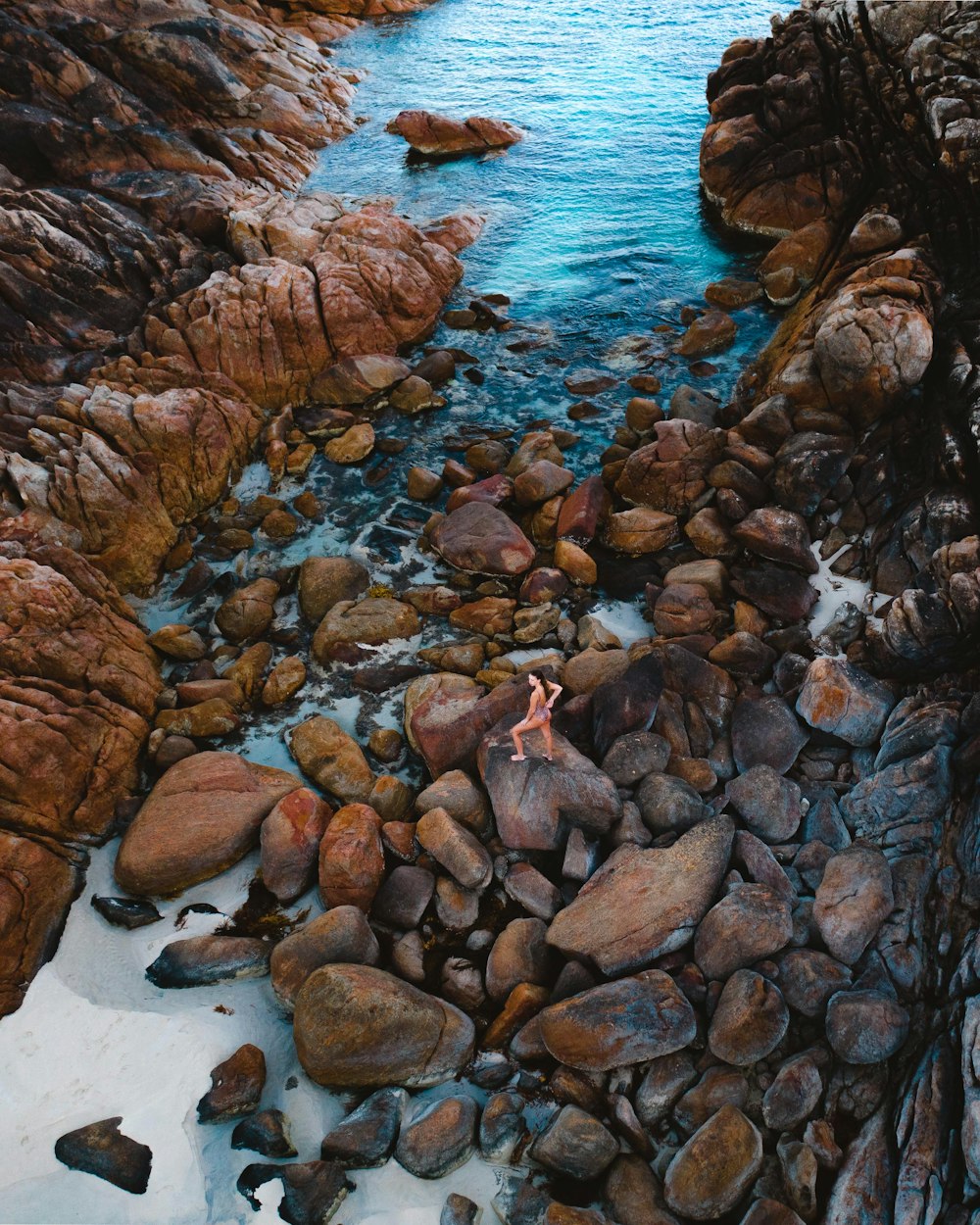 brown rocks on body of water during daytime