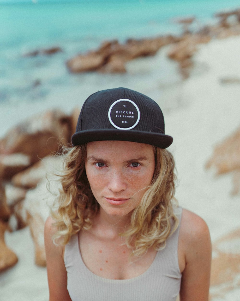 woman in white tank top wearing black and white fitted cap