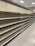 Empty supermarket shelves with product tags attached. The shelves are uniformly lined and the lighting suggests a bright indoor setting.