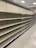 Empty supermarket shelves with product tags attached. The shelves are uniformly lined and the lighting suggests a bright indoor setting.