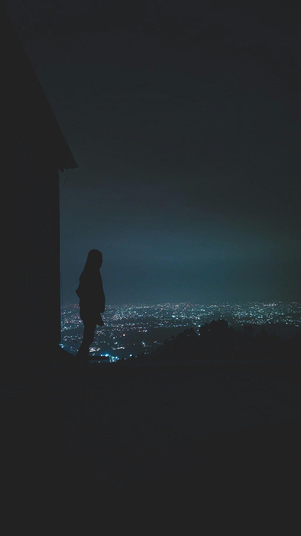 silhouette of person standing on rock formation during night time