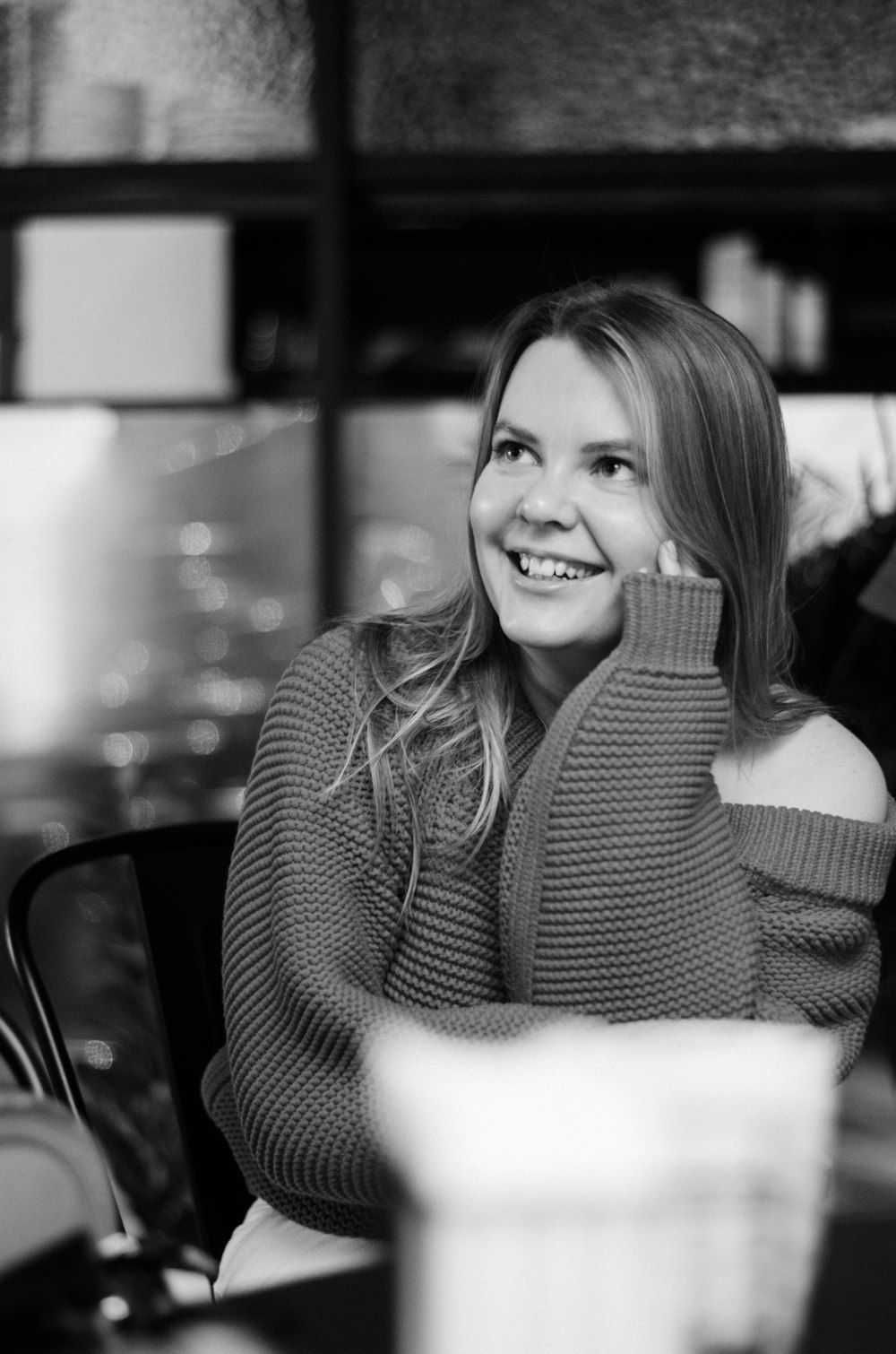 grayscale photo of woman in sweater smiling