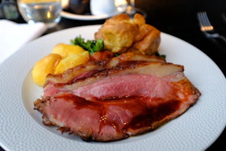 A traditional Yorkshire pudding served alongside a hearty Sunday roast on a rustic wooden table.