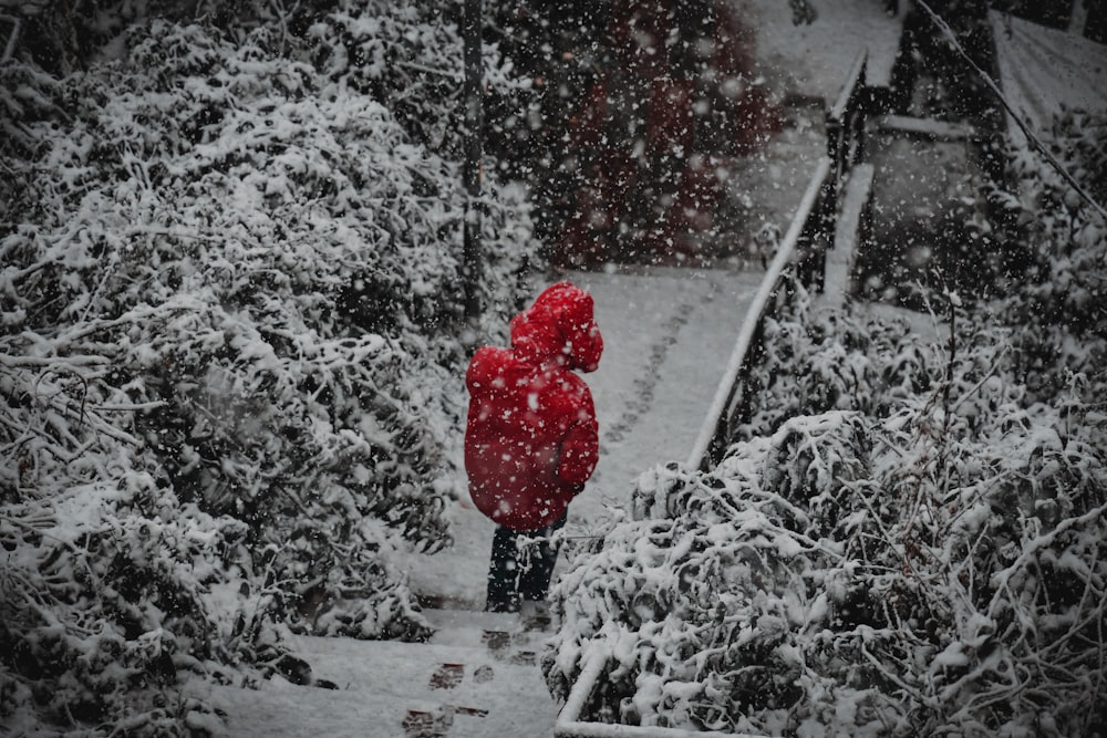 person in red hoodie standing on snow covered ground