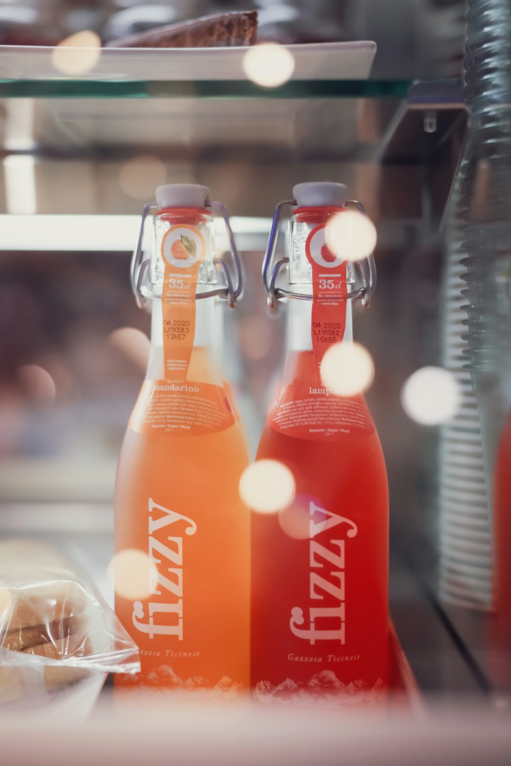 orange liquid in clear glass bottle