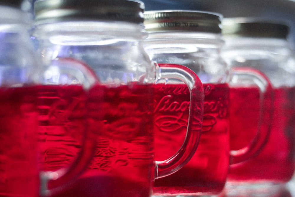 clear glass mug with red liquid inside