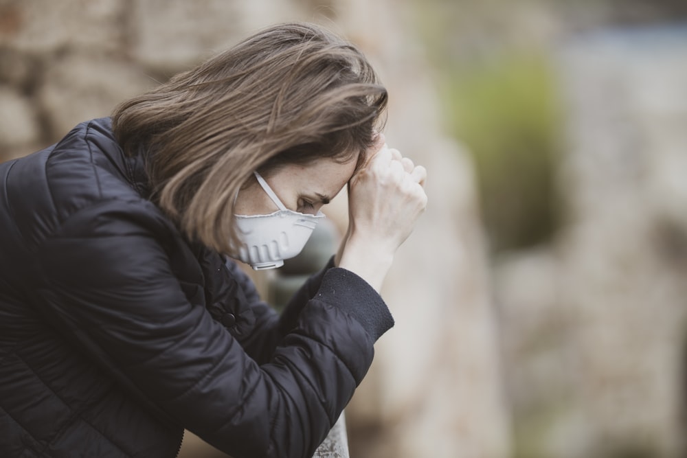 woman in black leather jacket wearing white framed eyeglasses covering her face