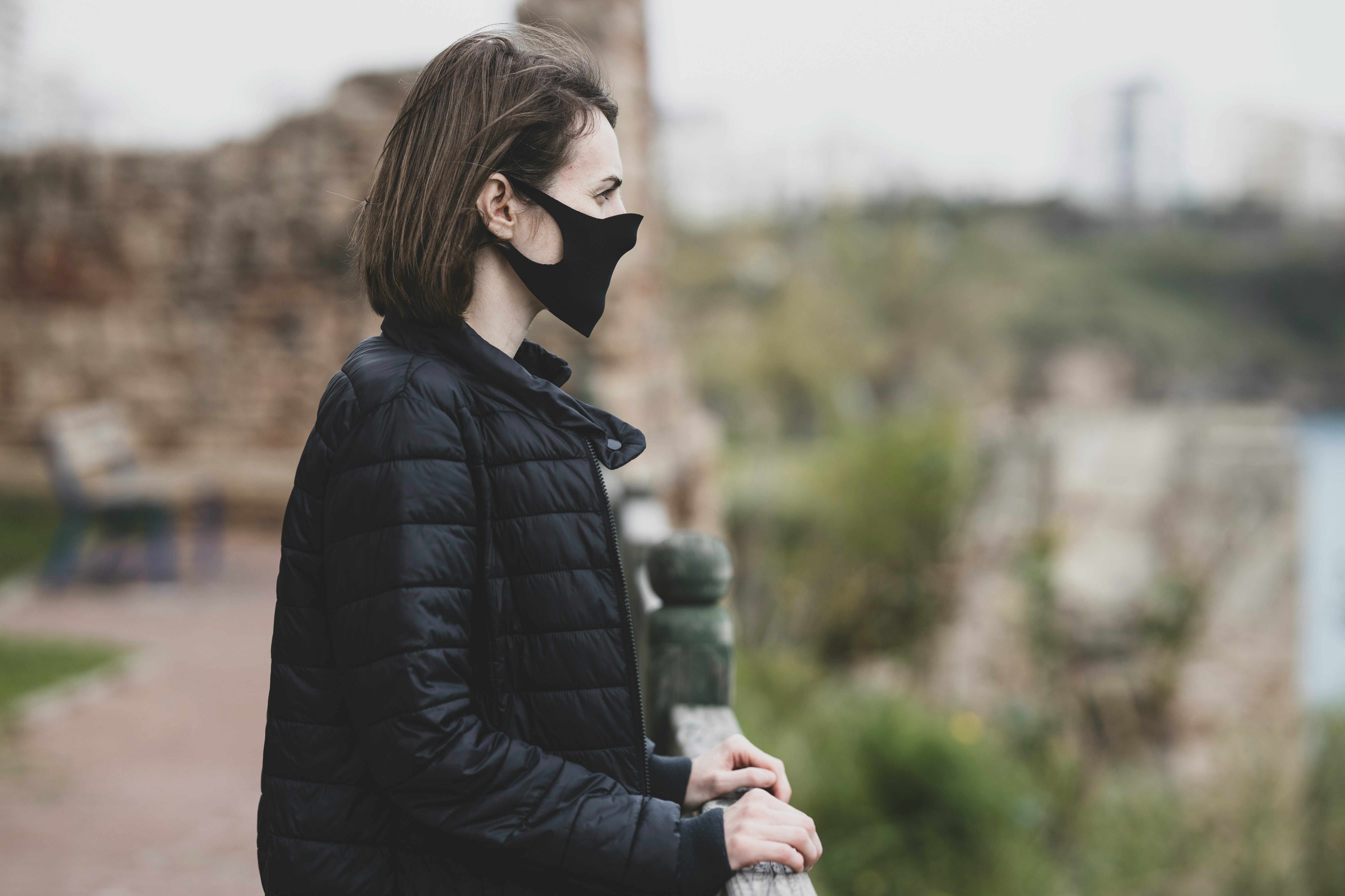 woman in black leather jacket wearing white mask