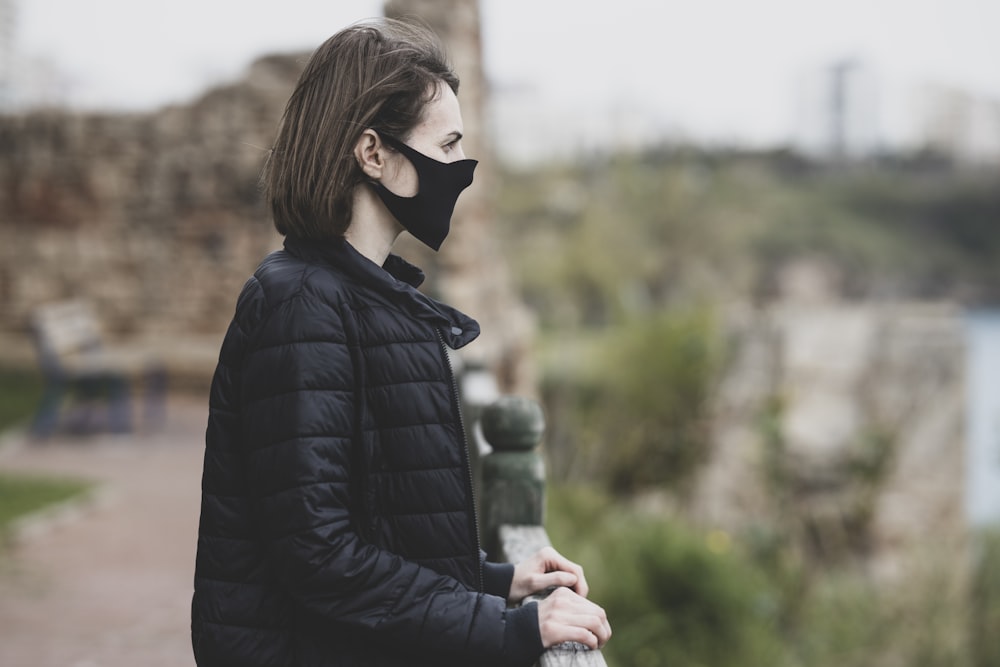 woman in black leather jacket wearing white mask