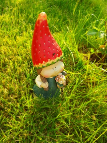 A freshly mowed yard with neat stripes and a colorful garden gnome waving nearby.
