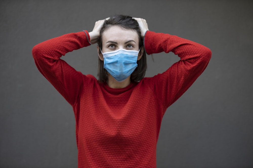 uomo in maglione rosso con maschera facciale