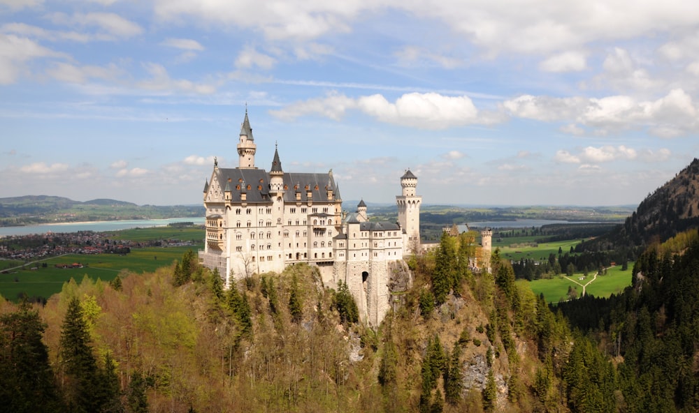 white concrete castle on top of hill during daytime