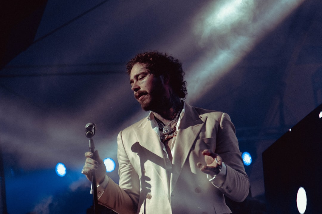 man in white dress shirt holding microphone