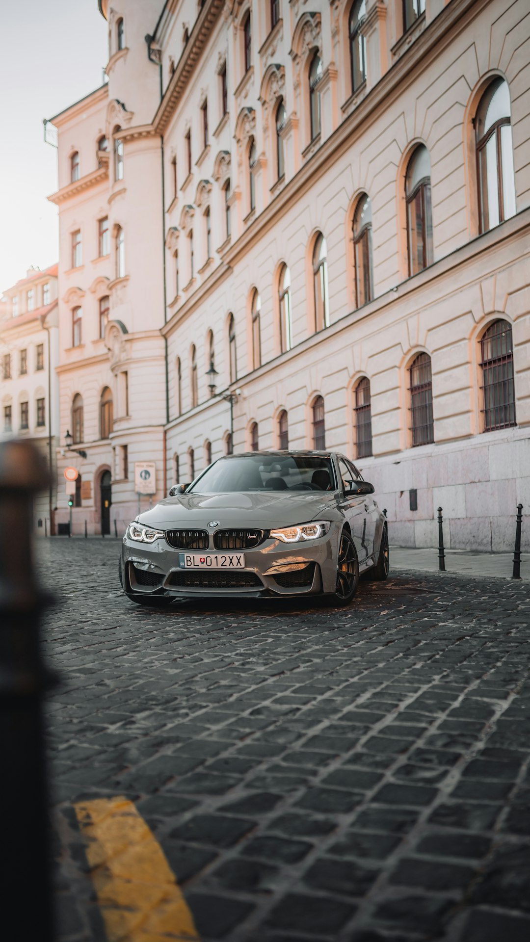 black mercedes benz coupe parked beside white concrete building during daytime