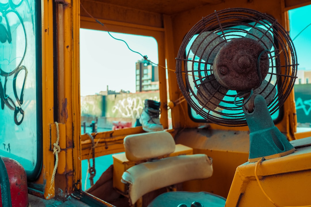 white and blue box fan on yellow leather chair