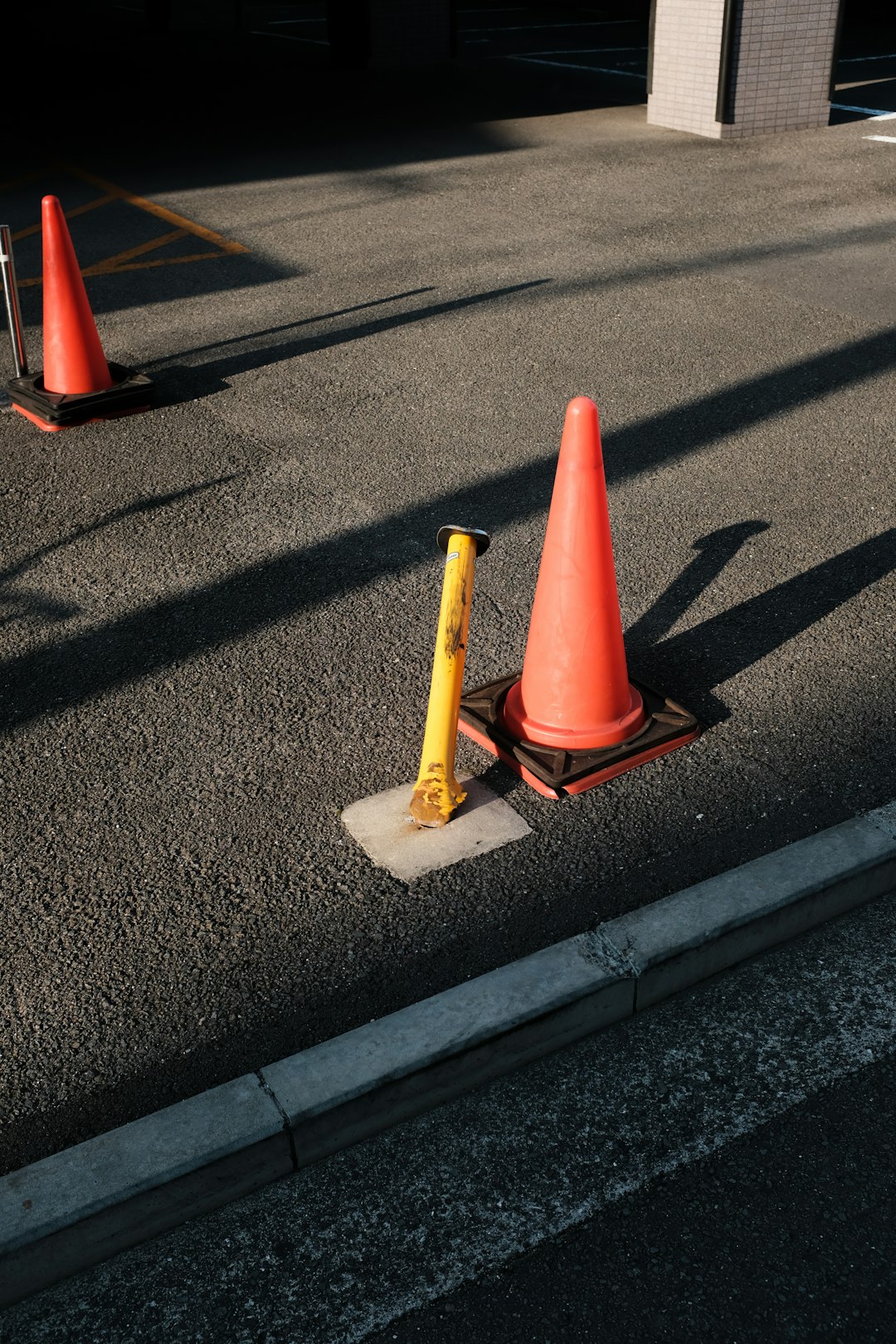 red and yellow traffic cone on gray asphalt road
