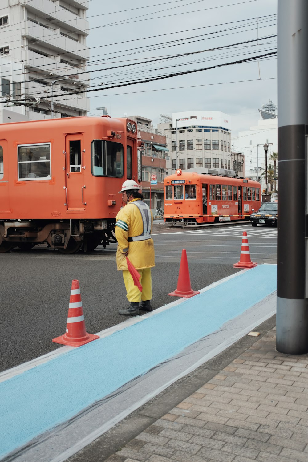 woman in yellow jacket standing beside yellow train during daytime