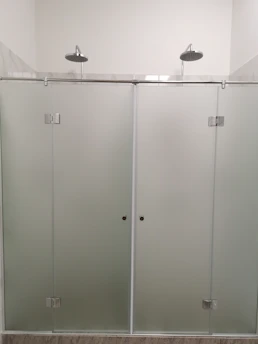 Sleek aluminum profiles framing a glass shower door in a bright bathroom