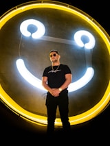 A smiling person standing confidently in front of a community center, representing support and progress.