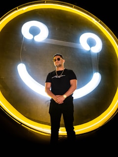 Smiling small business owner standing proudly next to their new outdoor yard sign.