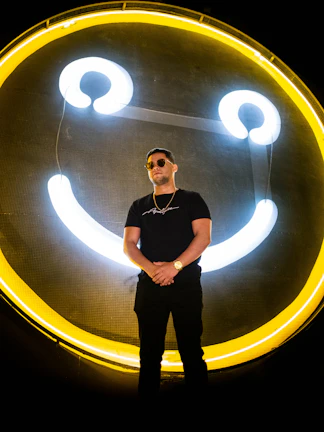 A glowing neon-lit digital avatar smiling confidently against a dark futuristic background.