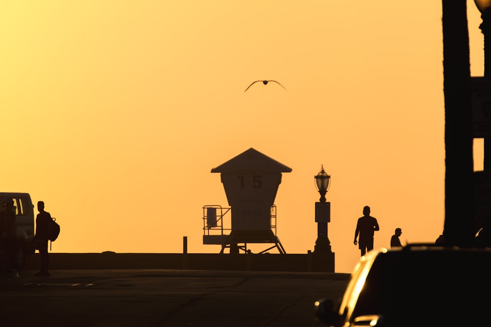 silhouette of people walking on street during sunset