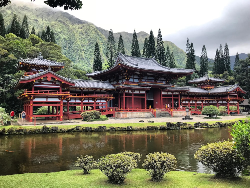 red and black temple near lake