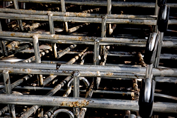 A stack of interlocking metal shopping carts with visible rust spots and signs of wear.